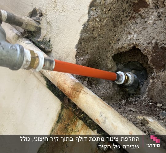 צינור מים מחובר לקיר עם סימני חלודה